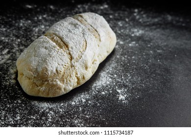 bread on a black background flour on the table
