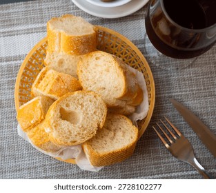 Bread sliced and served on table with olives and serving pieces