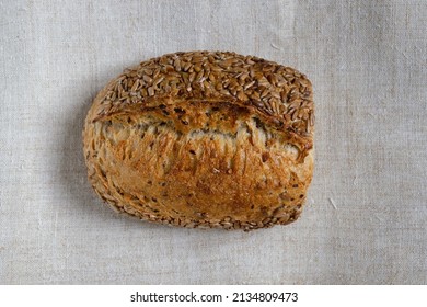 Bread with sunflower seeds on the hemp fabric. Crust. Wholemeal flour.