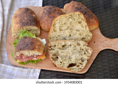 Bread Texture Of Ciabatta, Italian Flat Bread Cut In Half; Sandwich Bread Slices With Chopped Wild Garlic On Wooden Board With Smoked Ham And Cheese Sandwich, Garlic Bread Buns In Background  