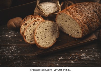 Bread, traditional sourdough loaf bread cut into slices on a rustic wooden background - Powered by Shutterstock