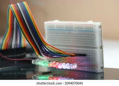 Breadboard with glowing lights from LED with reflections on the glass