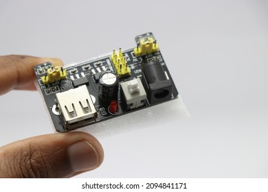 Breadboard power supply module held in hand isolated on white background