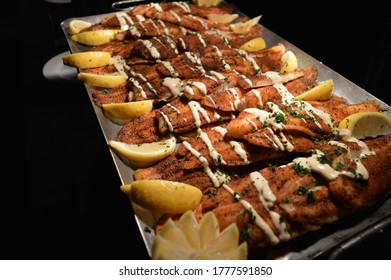 Breaded Catfish Filets Sauced On A Platter With Lemons 