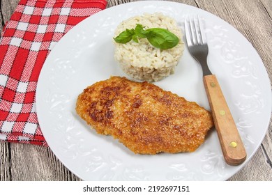 Breaded Chicken Cutlet And Rice On A Plate