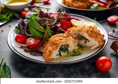 Breaded Chicken Kiev breast stuffed with butter, garlic and herbs served with vegetables in a plate. - Shutterstock ID 1032711094