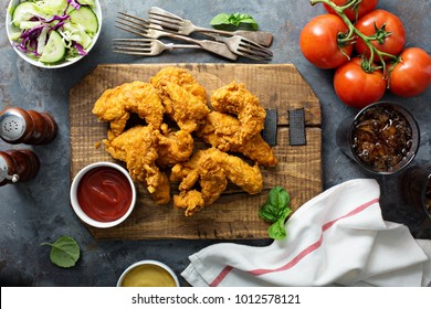 Breaded chicken tenders with ketchup, salad and soda - Shutterstock ID 1012578121