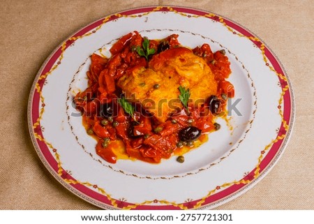 Breaded cod cooked in tomato sauce, olives, capers and parsley and served in a trattoria as a second course