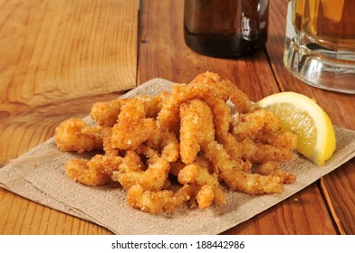 Breaded, Deep Fried Clam Strips With A Wedge Of Lemon And Beer