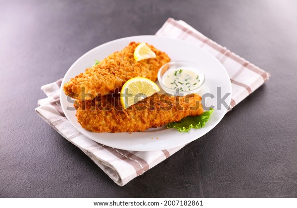 breaded fish with\
dipping sauce and lemon