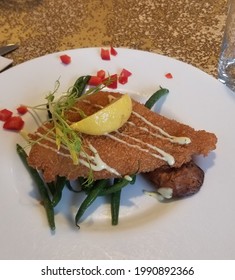 Breaded Flounder Fish With A Side Of String Beans, Garnished Beautifully