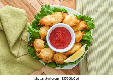 Breaded And Fried Butterfly Coconut Shrimp Served On Bed Of Romaine Lettuce With Spicy Cocktail Dipping Sauce