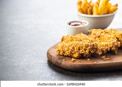 Breaded Fried Chicken Strips And Bbq Sauce On Wooden Cutting Board. Fast Food With French Fries. 