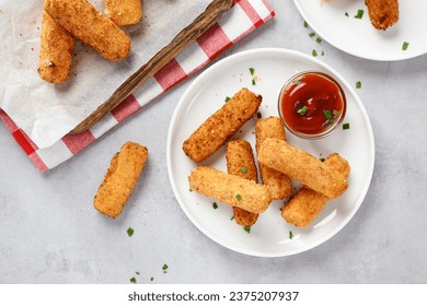 Breaded fried mozzarella cheese sticks with tomato  dipping sauce. Top view