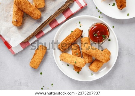 Breaded fried mozzarella cheese sticks with tomato  dipping sauce. Top view
