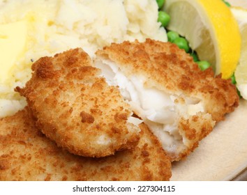 Breaded Haddock Fish Fillets Served With Mash And Peas.