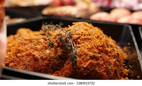 Breaded Pieces Of Raw Beef Meat With Rosemary Are Lying In Black Tray In The Store Refrigerator In Slow Mo Close Up Camera Motion 4K Video With No People