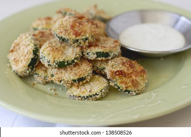 Breaded rounds of zucchini on a plate.