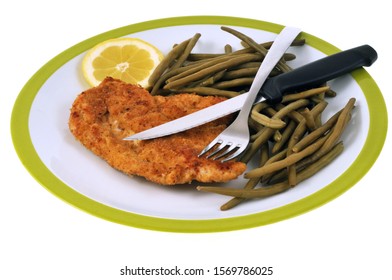 Breaded Veal Cutlet With Green Beans And A Slice Of Lemon In Closeup On White Background