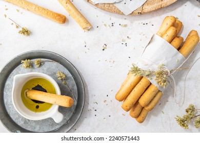 Breadsticks grissini. Bread sticks with sesame seeds, oregano and olive oil and balsamic vinegar on kitchen countertop. Top view. Flat lay with copy space - Powered by Shutterstock