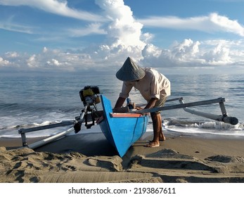 The breadwinner- A fisherman is pulling a boat into the ocean to look for fish, then the produce will be sold to the market. The money will be used for family needs. - Shutterstock ID 2193867611