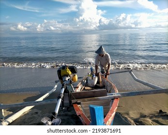 The breadwinner- A fisherman is pulling a boat into the ocean to look for fish, then the produce will be sold to the market. The money will be used for family needs. - Shutterstock ID 2193871691