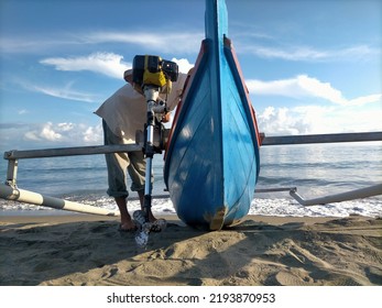 The breadwinner- A fisherman pulls a boat into the ocean in search of fish. His business helps the domestic fish industry, part of which is used for family consumption. - Shutterstock ID 2193870953
