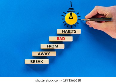 Break Bad Habits Symbol. Wooden Blocks On Blue Background, Copy Space. Light Bulb Icon. Businessman Hand With Pen. Words 'break Away From Bad Habits'. Break Bad Habits Concept. Copy Space.