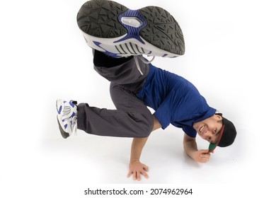A break dance dancer in a dance stand stands on his hands on a white background. Bboy.