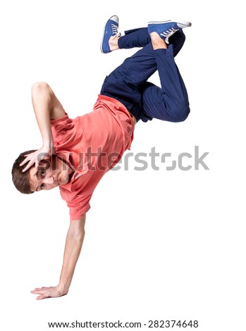 A teenage boy stretches down, pulling his head to his knees, outdoors