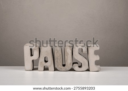 Break from German word PAUSE displayed with concrete letters on table