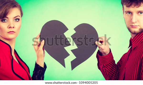 Break up and leave in relationship. Negative emotions\
between people in love. Young couple with two halves of broken\
heart. Lovers breaking\
up.