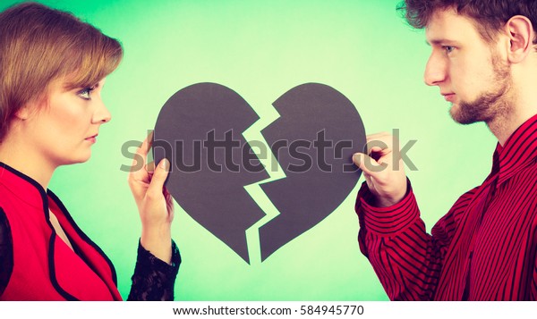 Break up and leave in relationship. Negative emotions\
between people in love. Young couple with two halves of broken\
heart. Lovers breaking\
up.