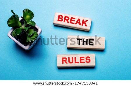 Break the rules - failure to comply - text on wood blocks on a blue background