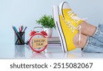 Break Time reminder or notice message. Red alarm clock with a note paper on office background with yellow sneakers on the office desk