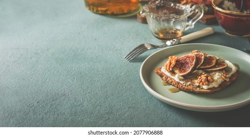 Breakfast Background With French Toast With Creme Cheese, Figs And Honey On Plate With Kitchen Utensils On Pale Blue Kitchen Table. Healthy Snack At Home. Top View.