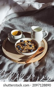 Breakfast In Bed With A Bowl Of Cereal, Fruit And Milk And A Cup Of Coffee On A Bed. Healthy Eating, Vertical. 