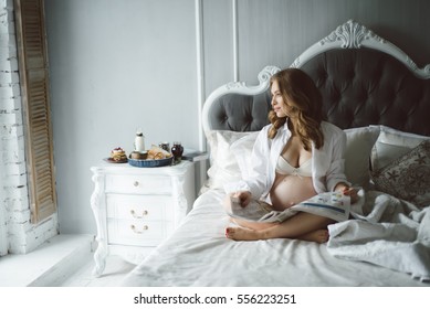 Breakfast in bed with the pregnant young girl