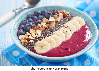 Breakfast berry smoothie bowl topped with blueberry,almond, banana and chia seeds