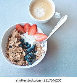 Breakfast Bowl With Greek Yoghurt, Blueberries, Strawberries And Full Corn Flakes. A Cup Of Coffee To Charge The Day.