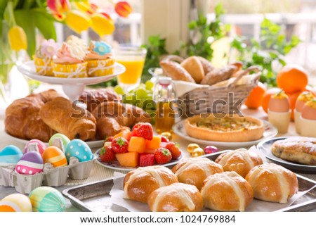 Breakfast or brunch table filled with all sorts of delicious delicatessen ready for an Easter meal.