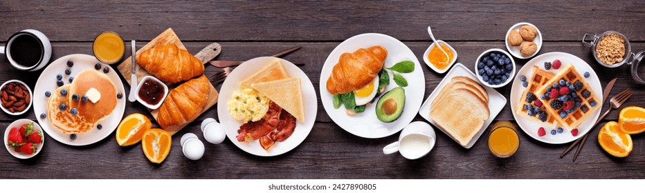 Breakfast or brunch table scene on a dark wood banner background. Top view. Assortment of sweet and savory food items. - Powered by Shutterstock