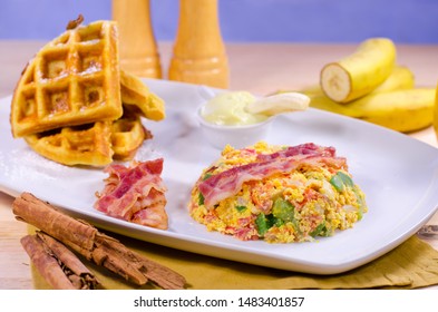 Breakfast Brunch Table With Scrambled Eggs, Veggies, Bacon, Waffles, Banana Pudding, Orange Juice, Waffles On White Plate. Restaurant Style. 