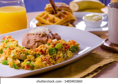 Breakfast Brunch Table With Scrambled Eggs, Veggies, Bacon, Waffles, Banana Pudding, Orange Juice, Waffles On White Plate. Restaurant Style. 