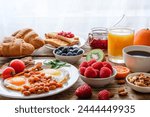 Breakfast buffet. Full english and continental breakfast. Large selection of brunch food on the table with egg, bacon, toast, orange juice, croissant, coffee, fruits and nuts