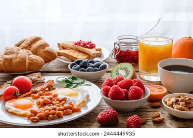 Breakfast buffet. Full english and continental breakfast. Large selection of brunch food on the table with egg, bacon, toast, orange juice, croissant, coffee, fruits and nuts - Powered by Shutterstock