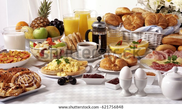 BREAKFAST BUFFET TABLE FILLED WITH
ASSORTED FOODS,SAVOURY,SWEET,PASTRIES,HOT AND COLD
DRINKS