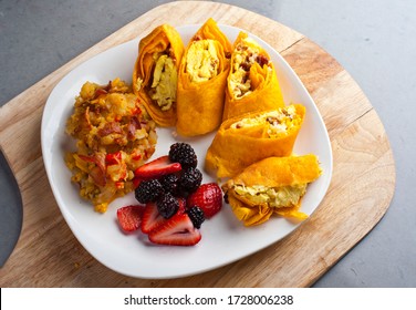Breakfast burrito. Bacon, eggs, onions, peppers sautéed and wrapped a flour tortilla. Served with salsa, potato hash, blueberries and blackberries. Classic breakfast or brunch menu favorite.