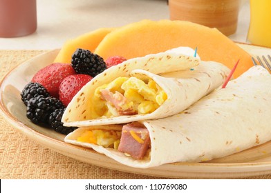 A breakfast burrito with fresh berries and fruit