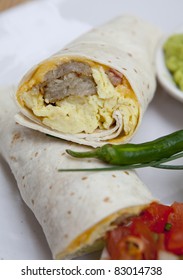 Breakfast burrito, in mexican style,with guacamole, eggs, spice and tomato.